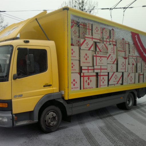 Брендування вантажного автотранспорту “Нова пошта” з поклейкою ребристих дахів мікроавтобусів та повним брендуванням причепів фур